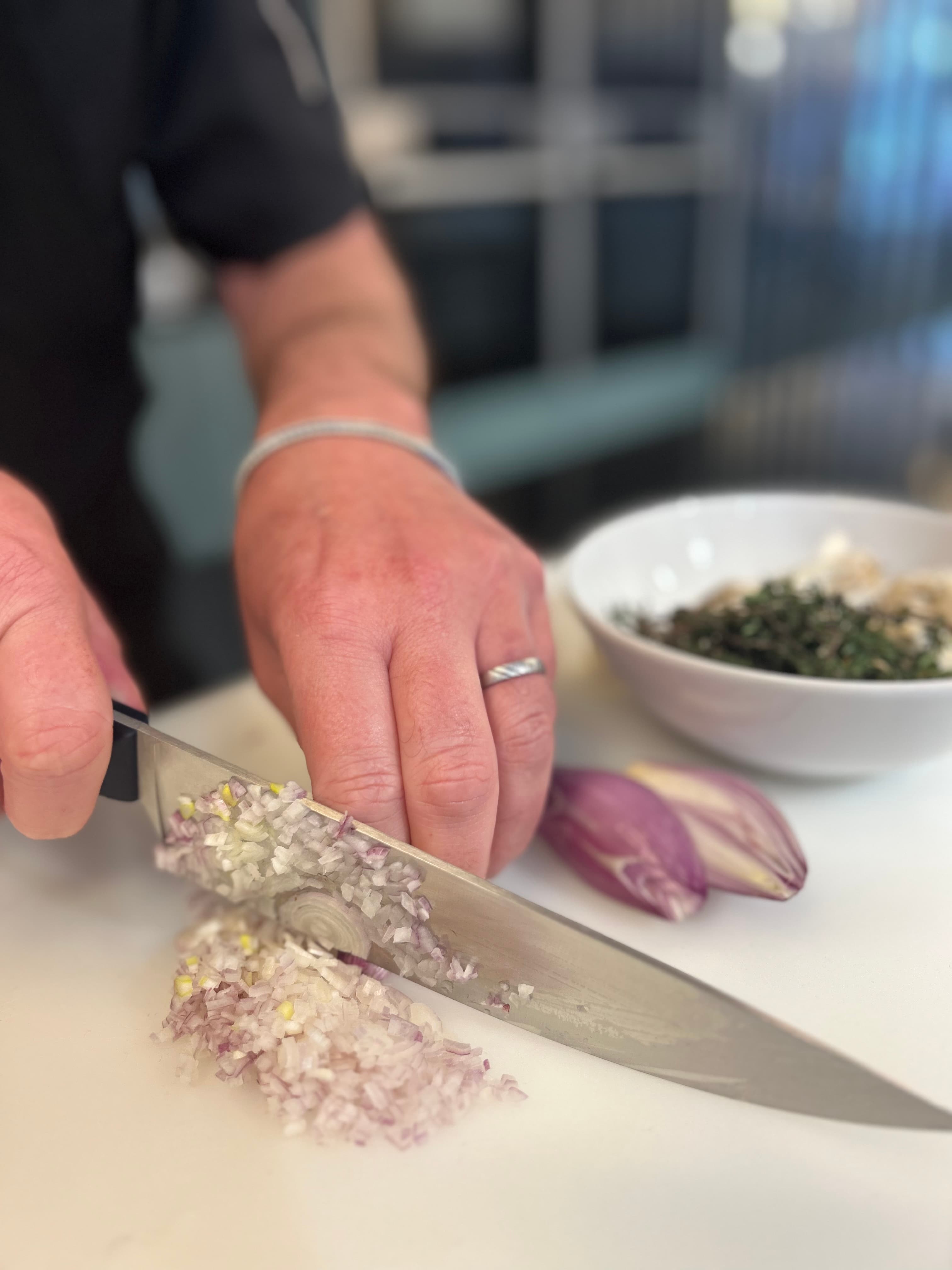 Geste technique au couteau du chef pendant un cours de cuisine au 3ème Cercle, Paris 11